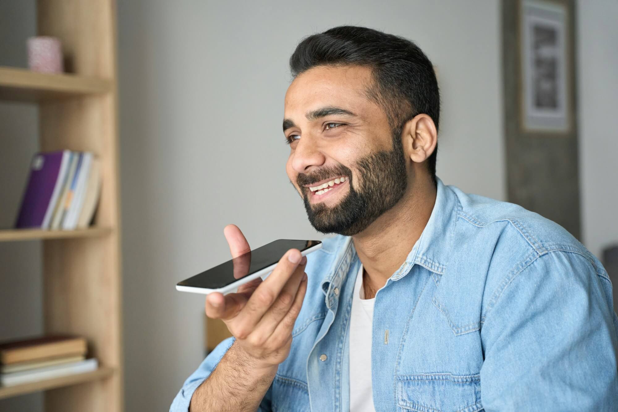 young-indian-man-speaking-to-voice-assistant-using-smartphone-.jpg young-indian-man-speaking-to-voice-assistant-using-smartphone-.jpg